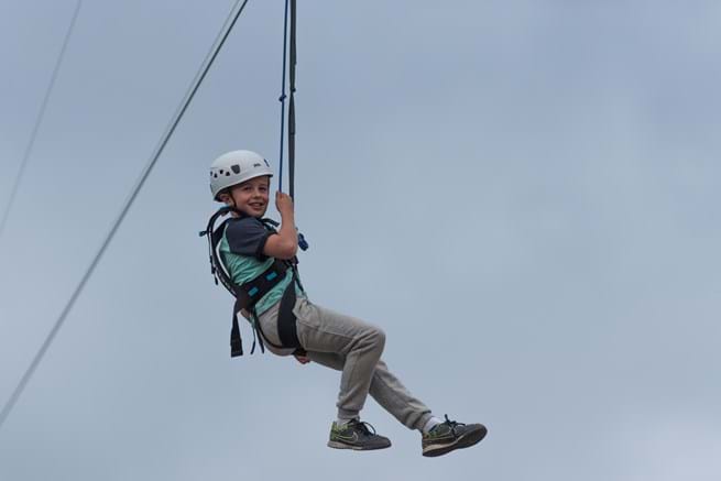 jongen zipt aan zipline bij klimpark Adventure City Rotterdam