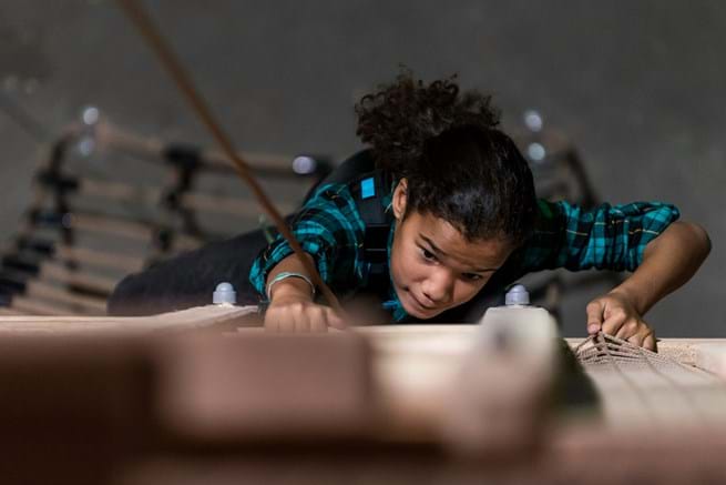 meisje klimt aan klimmuur bij klimpark Adventure City Rotterdam