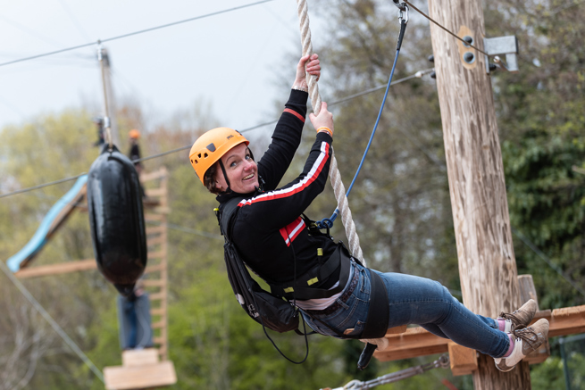 vrouw zipt aan zipline bij outdoor klimpark Adventure City Rotterdam